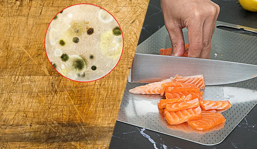 A worn wooden board beside a metal board being used to slice salmon.