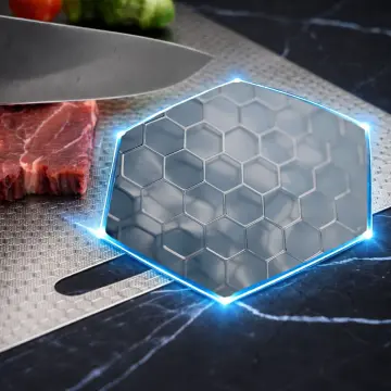 Close view of a textured metal cutting board with a decorative blue outline.